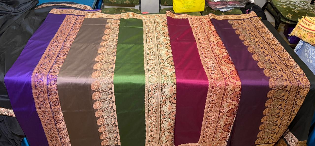 A flat-lay of Banarasi silks with gold zari borders