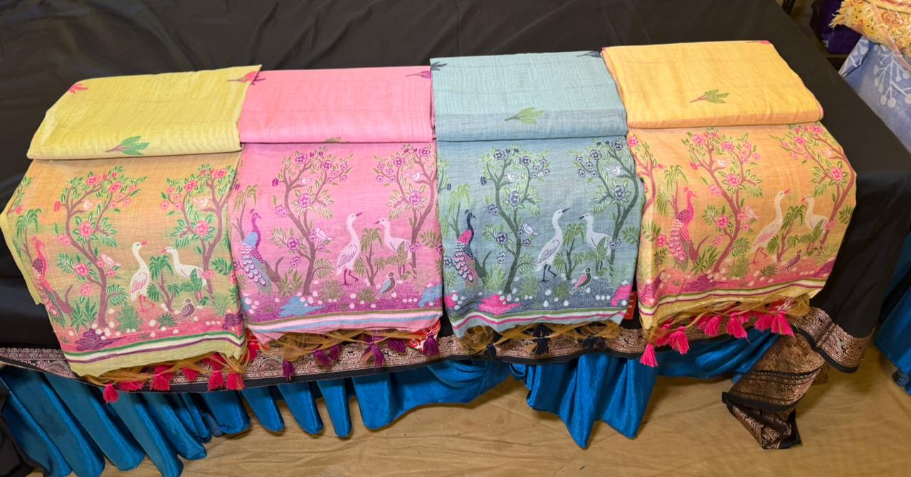 Pastel saris with bird and floral motifs on display